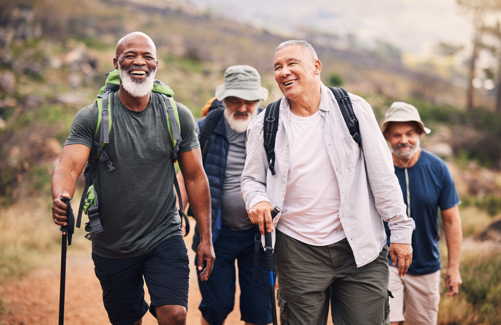 older men hiking in nature with trekking poles